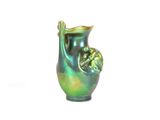 un vase vert posé sur une surface blanche