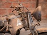 an old motorcycle that is parked in front of a brick wall