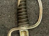 a silver and gold sword on a black cloth