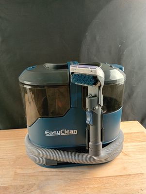 un aspirateur posé sur une table en bois