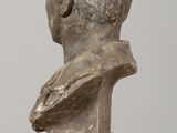statue of a bust of a man sitting on a wooden table