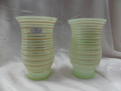 deux vases verts posés l'un à côté de l'autre sur une nappe blanche