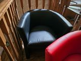 a red and black chair and a black chair in a living room
