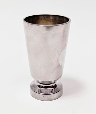 une coupe en argent posée sur un socle en métal