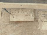 a piece of paper with writing on it sitting on a piece of wood