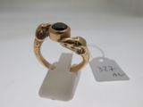 l'image d'une bague en or ornée d'une pierre noire
