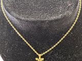 a gold necklace with a cross on a mannequin neck