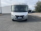 a white rv parked in a parking lot next to a building