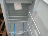 a white refrigerator with its door open on a pallet