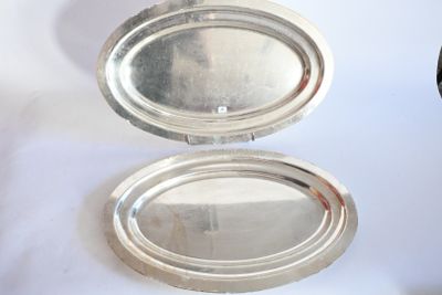 deux plateaux en argent posés l'un à côté de l'autre sur une table