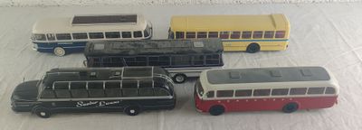 quatre petits bus alignés sur une table