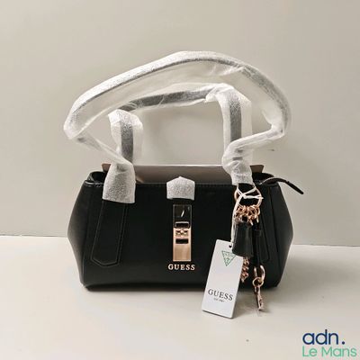 Le petit sac à main noir est muni d'un porte-clés accroché à sa poignée.