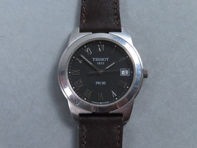 gros plan d'une montre avec des chiffres romains sur le cadran