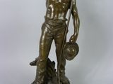 bronze statue of a man holding a dog and a hat