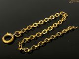 a close up of a gold chain on a black surface