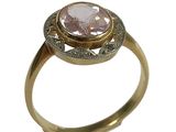 une image d'une bague en or avec une pierre rose au centre