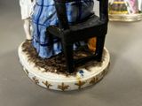 a figurine of a woman sitting on a chair