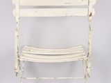 an old white metal chair with a wooden seat on a grey background
