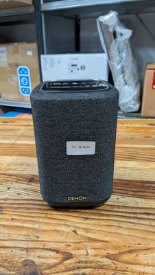 une image représentant une enceinte noire posée sur une table en bois