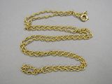 a close up of a gold chain on a gray surface