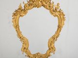 un miroir doré richement décoré accroché au mur d'une pièce