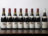 six bouteilles de vin sont alignées sur une table en bois
