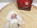 a small doll that is sitting on a table next to a book