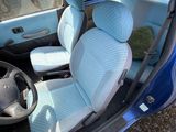 une photo d'une voiture bleue avec un ours en peluche sur le siège passager