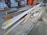 un tas de bois posé par terre devant un tas de palettes