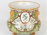 a green and yellow vase with a bird on it