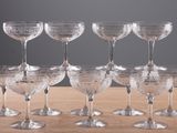 six clear wine glasses sitting on top of a wooden table