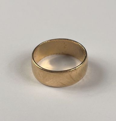 une image d'un gros plan d'une bague en or sur une surface blanche