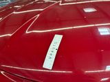 a close up of a red car with a sticker on it