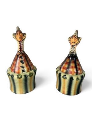 paire de figurines en céramique représentant un homme et une femme au sommet d'un chapiteau de cirque