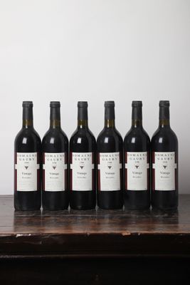six bouteilles de vin sont alignées sur une table en bois