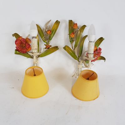 deux vases jaunes contenant des fleurs, posés sur une surface blanche