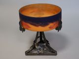 a bowl on a stand with a bird on top of it
