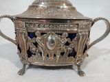 un plateau en argent orné de verre bleu, posé sur un fond blanc