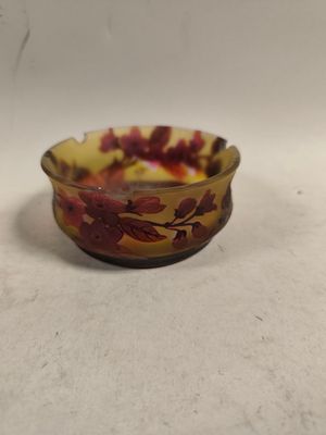 un petit bol en verre orné d'un motif rouge et jaune
