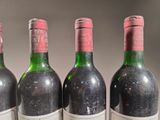 three bottles of red wine are lined up on a table