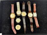 Plusieurs modèles de montres sont exposés dans une vitrine.
