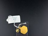 a close up of a gold leaf charm on a black box