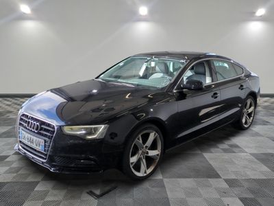 the black audi sedan is parked in a large room