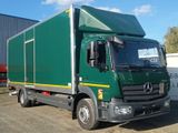 a green truck parked in front of a building
