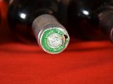 several bottles of wine are lined up on a red cloth