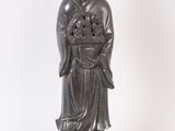 une statue ancienne représentant une femme tenant une fleur sur un socle