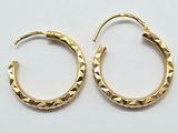 une paire de boucles d'oreilles créoles dorées sur un fond blanc