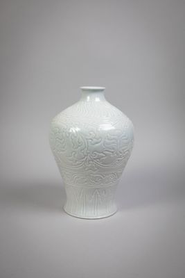a white vase sitting on a table with a gray background