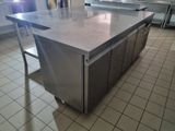 une grande cuisine avec un îlot en inox au milieu de la pièce