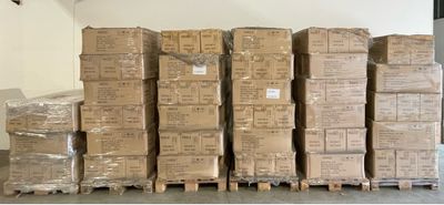de nombreux cartons empilés sur des palettes dans un entrepôt